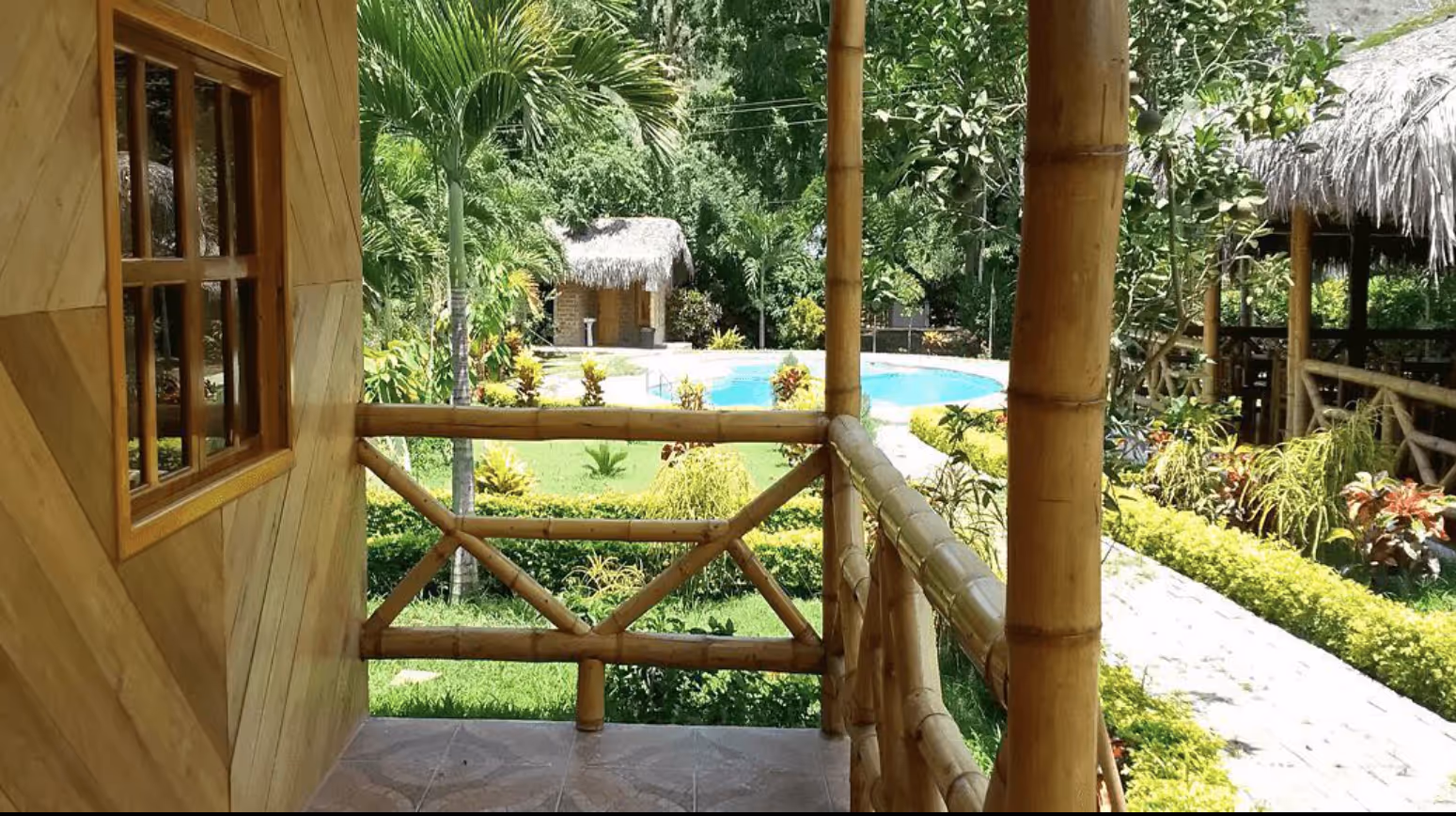 Garden with bamboo pavilion and tropical palms at the Hostería Arandú